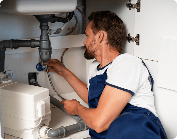Plumber working under sink